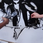 hands taking down plastic sheet from grafitti in process