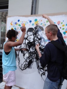 artist nancy rhode and a friend taking down a plastic sheet from a grafitti in process