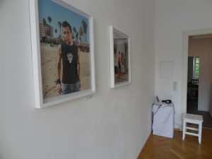 two photographs hanging on the wall and a little station with one laptop in the corner of the room